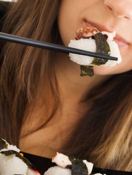 Woman eating sushi, close up