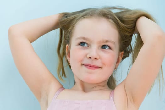 Portrait of cute girl with upwards hands and blond hair