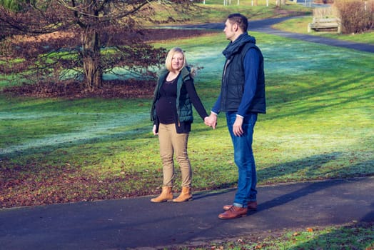 young pregnant woman with her husband in the park