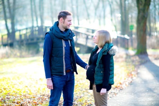 young pregnant woman with her husband in the park