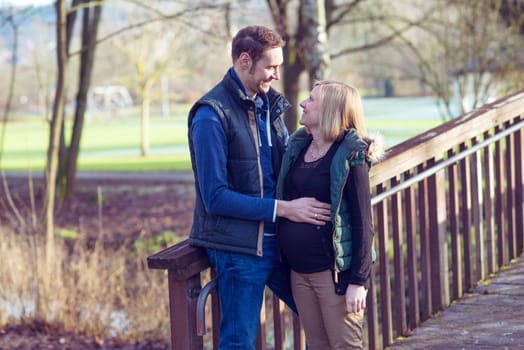 young pregnant woman with her husband in the park