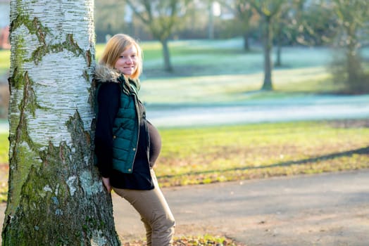 young blond pregnant woman alone the park