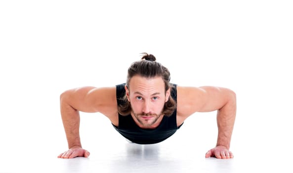 young man doing press-up in front of white background