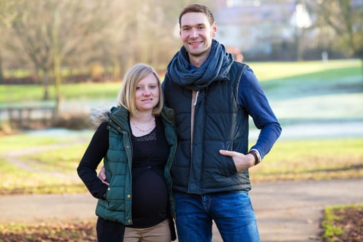 young pregnant woman with her husband in the park