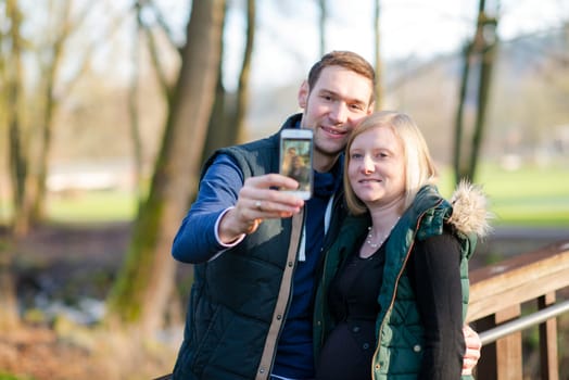 young pregnant woman with her husband in the park