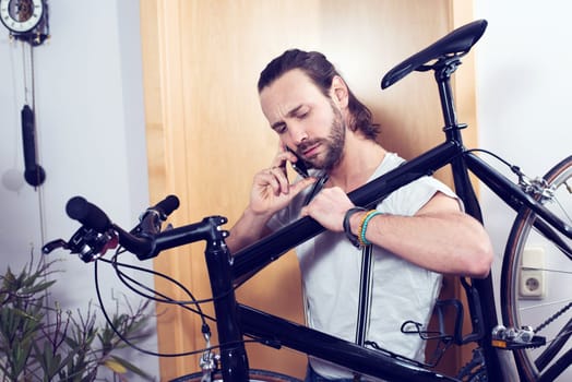 young bearded man calling with bike on the shoulder