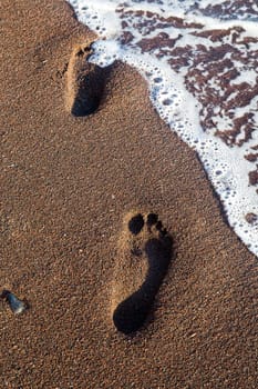 Trail of foot steps on the beach