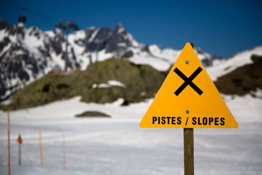 A sign warning for slopes in a ski domain