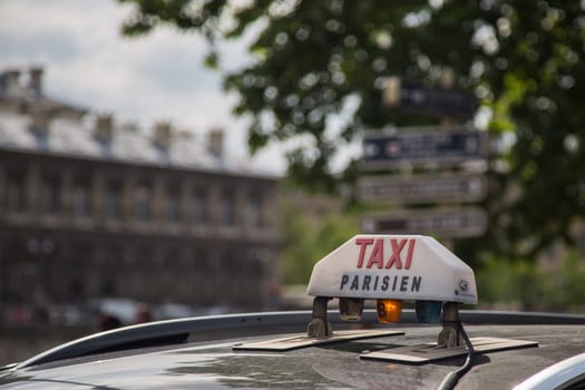The Taxi sign on top of the roof of the cab in Paris