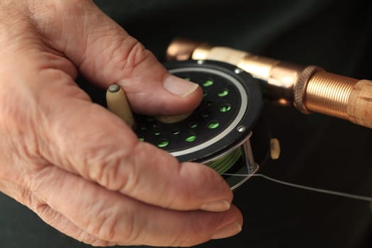 closeup view of a man's hand on his fishing reel