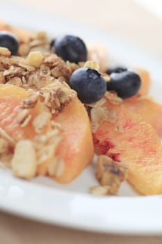 Fresh peaches and blueberries with granola sprinkled over