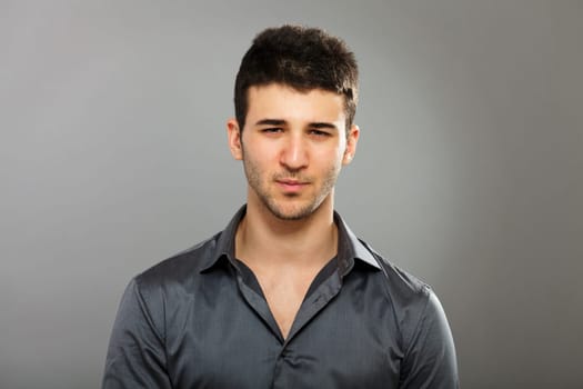 Young businessman portrait isolated on gray background.
