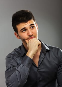 Young businessman looking right, isolated on gray background