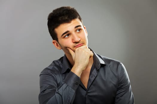 Young businessman portrait isolated on gray, horizontal shot