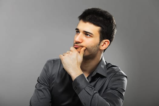 Young businessman portrait isolated on gray background. Side view.