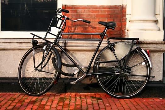 Iconic bicycle resting on the wall of a classic brick building, Amsterdam, Netherlands