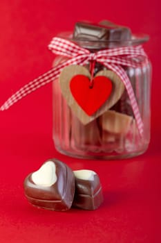 Chocolate in a jar on red background. Valentines day concept.