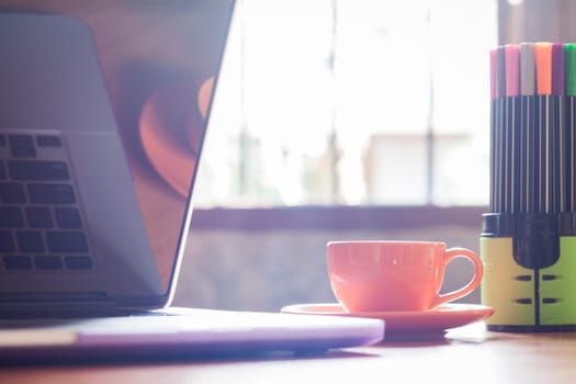 Coffee cup with keyboard on wooden table, stock photo