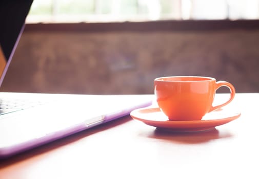 Coffee cup with keyboard on wooden table, stock photo