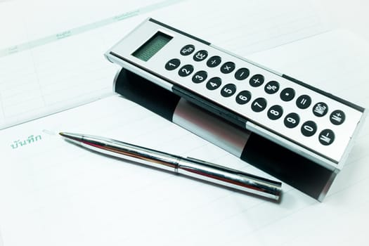 Pocket calculator and pen on the table, stock photo