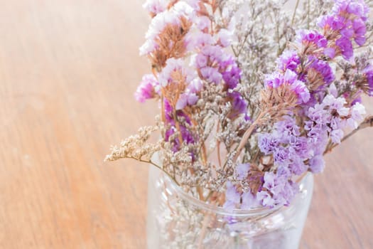 Beautiful statice flower bouquet on wooden table, stock photo