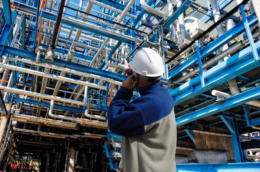 oil and gas worker with large pipelines construction, inside oil and gas refinery