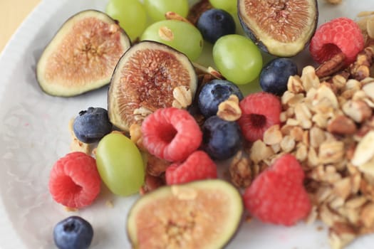 Fresh figs, blueberries, raspberries and grapes with a portion of granola