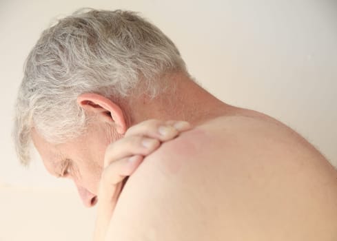 Older man with an itchy rash on his back