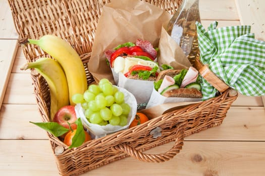 Basket for a picnic with sandwich and fruit