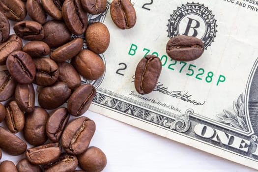 Coffee beans scattered on dollar. The concept of the price of coffee on the market
