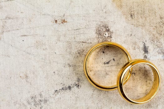 Wedding rings on dirty canvas with copy-space for text