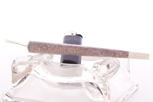 Cannabis marijuana with water pipe and joint with grass and ashtray close-up