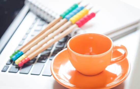 Laptop with coffee cup and notepad on desk, stock photo