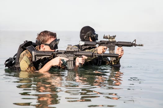 Navy SEAL frogmen with complete diving gear and weapons in the water
