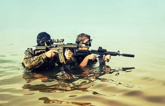 Navy SEAL frogmen with complete diving gear and weapons in the water