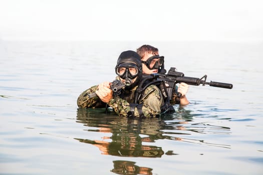 Navy SEAL frogmen with complete diving gear and weapons in the water