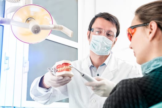 dentist shows professional tooth cleaning