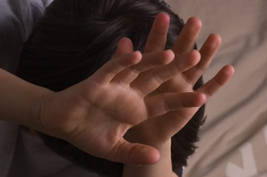 Child raising hands to protect itself