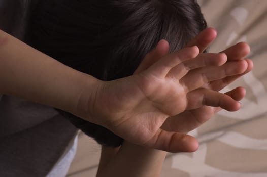 Child raising hands to protect itself