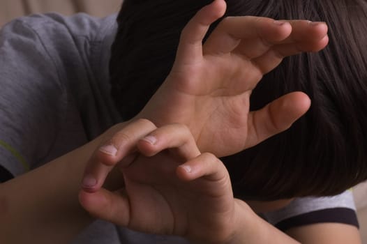 Child raising hands to protect itself