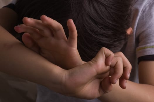 Child raising hands to protect itself