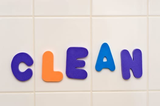 Foam letters on shower wall saying CLEAN