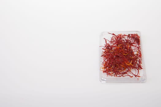 Little plastic box of spanish Saffron Isolated on white background