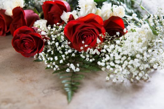 Vibrant red roses with baby's breath and white carnations for Valentine's Day.