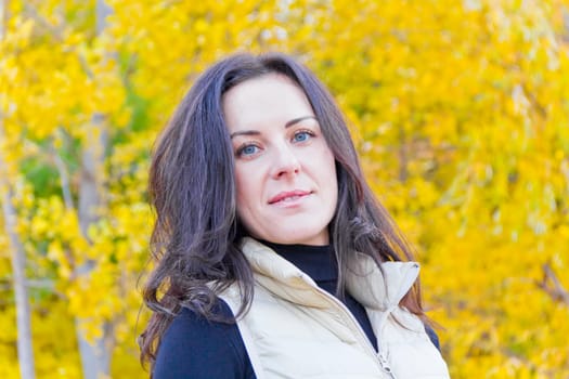 Portrait of beautiful brunette on yellow forest