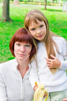 Photo of mother and daughter eating banana