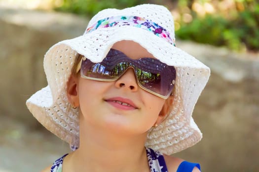 Cute girl in sunglass and white hat
