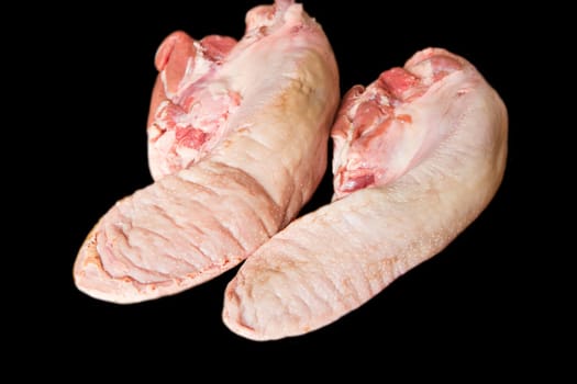 Photo of raw pork tongue on black background