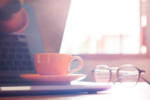 Coffee cup with keyboard on wooden table, stock photo