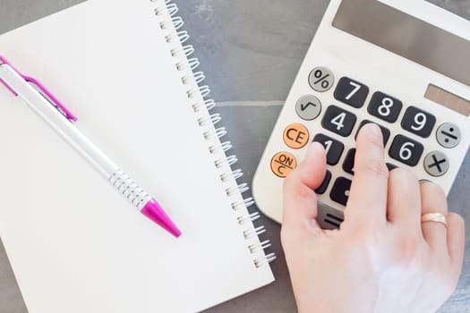 Hand with calculator and notepad, stock photo